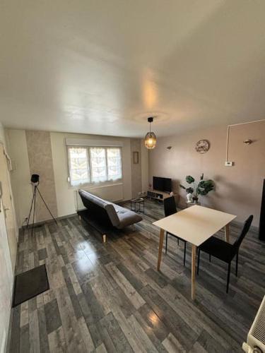 un salon avec un canapé et une table dans l'établissement 1 chambre de charme, à Valenciennes