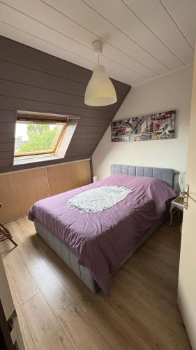 - une chambre mansardée avec un lit violet dans l'établissement Un ptit coin de paradis chez JF et Daisy à Plouescat, à Plouescat