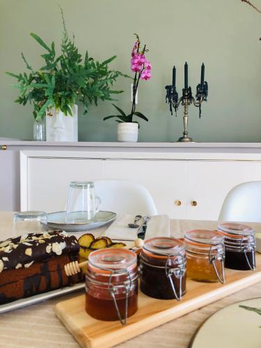 une table avec des pots de miel et un gâteau dans l'établissement Au Pré de Karine, à Cunèges