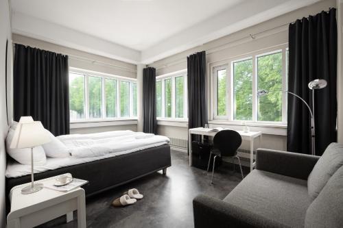 1 dormitorio con cama, escritorio y sofá en Hotel CityHovi en Rauma