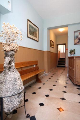 a hallway with a bench and a vase of flowers at Apartments and rooms by the sea Podgora, Makarska - 2623 in Podgora