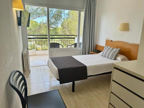 a hotel room with a bed and a balcony at Cabot Cala Ferrera in Cala d´Or