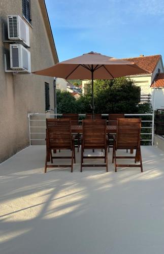 a table and chairs with an umbrella on a patio at Nona - 200m from the beach in Jadranovo