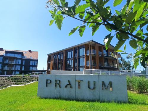 a building behind a sign in front of a building at P R A T U M 17 Apartament z widokiem na jezioro in Mikołajki