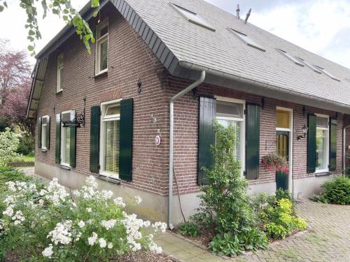 Nistelrode的住宿－Nisterlo Guesthouse，砖屋,上面有绿色百叶窗