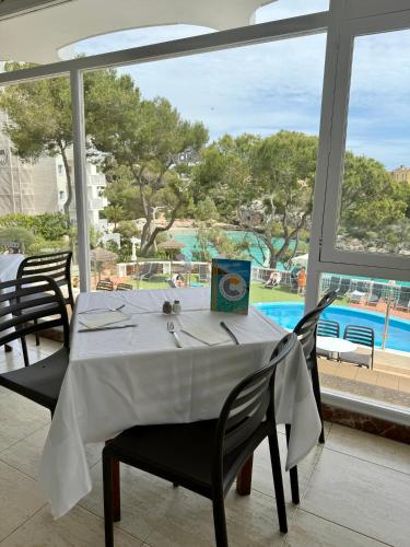 a dining room with a table and a view of a pool at Cabot Cala Ferrera in Cala d´Or