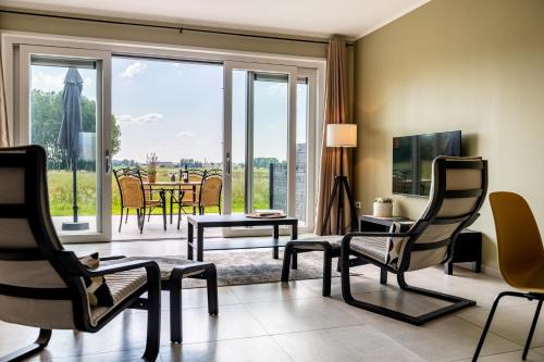 a living room with a table and chairs and a large window at B&B Alemsche Waard in Alem