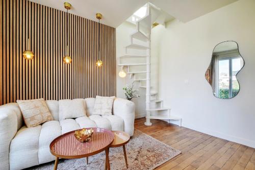 un salon avec un canapé blanc et une table dans l'établissement Cosy Duplex, à Boulogne-Billancourt
