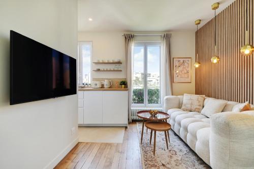 un salon avec un canapé et une télévision à écran plat dans l'établissement Cosy Duplex, à Boulogne-Billancourt