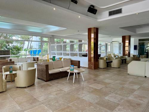 a lobby with couches and tables and chairs at Cabot Cala Ferrera in Cala d´Or