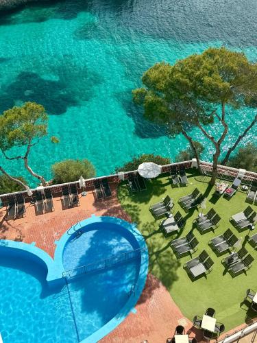 an overhead view of a large pool with chairs and water at Cabot Cala Ferrera in Cala d´Or