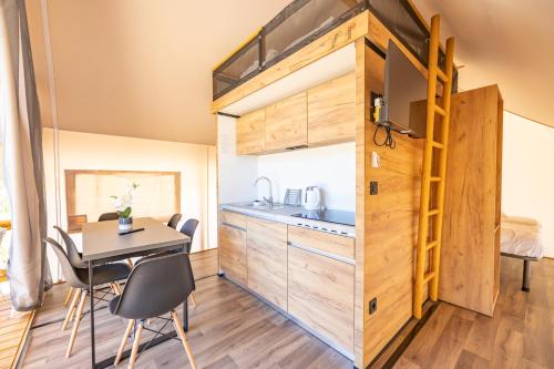 een tiny house met een keuken en een tafel en stoelen bij Glamping & Holiday Home experience - Camp Dole in Živogošće