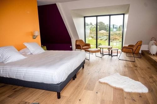 ein Schlafzimmer mit einem Bett, Stühlen und einem Tisch in der Unterkunft les ajoncs d or, Ploumanach Exceptionnelle in Perros-Guirec