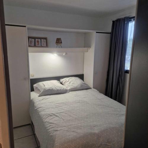 une petite chambre avec un lit et une fenêtre dans l'établissement Au bord de mer, à Sainte-Marie-la-Mer