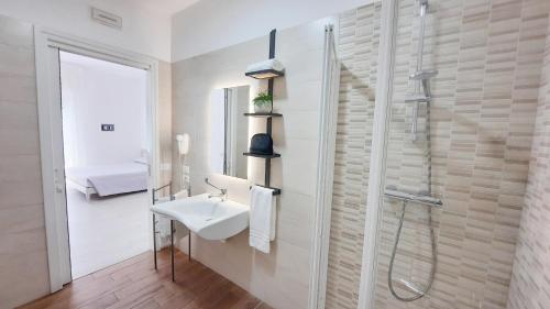 a white bathroom with a sink and a shower at Villa Serena in Lido di Jesolo