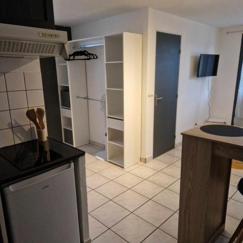 une cuisine avec un comptoir et une pièce avec des étagères dans l'établissement Au bord de mer, à Sainte-Marie-la-Mer