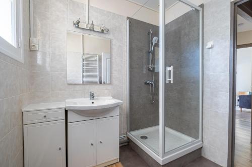 une salle de bain avec un lavabo et une douche dans l'établissement Les Alséides - Appt à 200 m de la plage, à La Baule