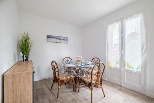 une salle à manger avec une table et des chaises en verre dans l'établissement Les Alséides - Appt à 200 m de la plage, à La Baule