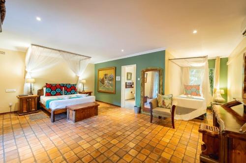 a bedroom with a bed and a tub in a room at Bayete Guest Lodge in Victoria Falls