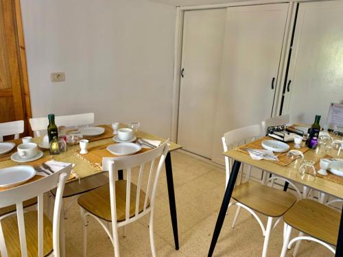 una sala da pranzo con un tavolo di legno con sedie bianche di Tamalou Djerba a Midoun