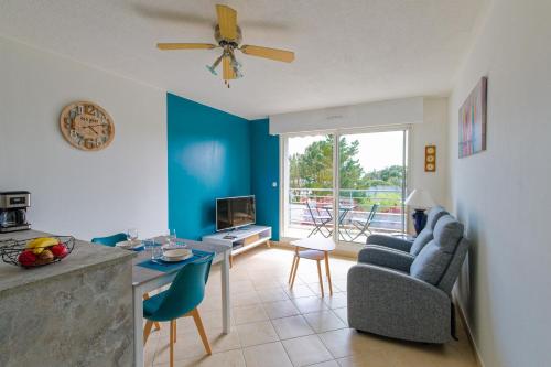 un salon avec un mur d'accent bleu dans l'établissement L'Escale des Jaunais - A moins d'1 km de la plage, à Pornichet