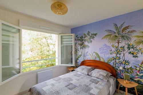 - une chambre avec un lit et une fresque murale de palmiers dans l'établissement L'Escale des Jaunais - A moins d'1 km de la plage, à Pornichet