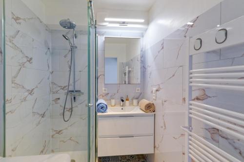 une salle de bain avec douche et lavabo dans l'établissement L'Escale des Jaunais - A moins d'1 km de la plage, à Pornichet
