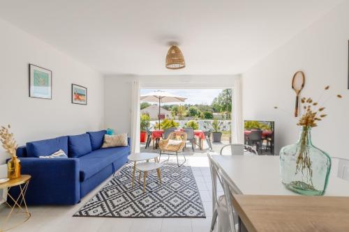 un salon avec un canapé bleu et une table dans l'établissement Les Tonnelles - Maison proche plage - Grand jardin, à Saint-Jean-de-Monts