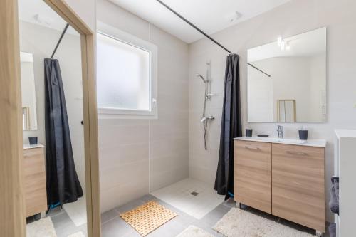 une salle de bain avec une douche, un lavabo et un miroir dans l'établissement Les Tonnelles - Maison proche plage - Grand jardin, à Saint-Jean-de-Monts