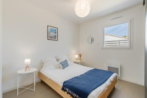 une chambre blanche avec un lit et une fenêtre dans l'établissement Les Tonnelles - Maison proche plage - Grand jardin, à Saint-Jean-de-Monts