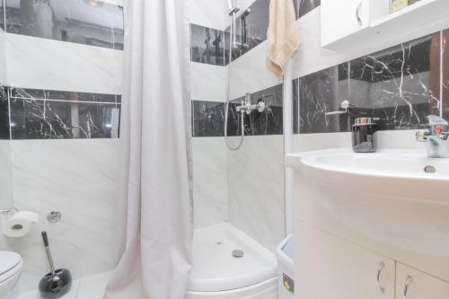 a white bathroom with a shower curtain and a sink at New! Apartment Aenona 200m from the beach, Nin in Nin
