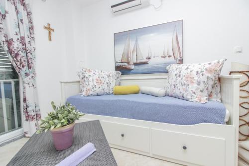 a room with a bench with a painting of sailboats at New! Apartment Aenona 200m from the beach, Nin in Nin