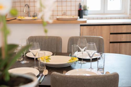 a table with wine glasses and plates on it at Apartments Leonel by Locap Group in Piran