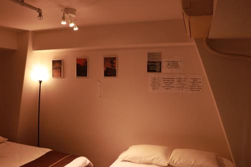 1 dormitorio con 1 cama y una luz en la pared en Imperial 心斎橋本町, en Osaka