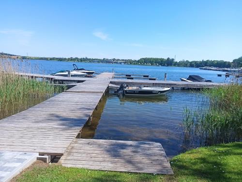 a dock with boats docked on a lake at P R A T U M 17 Apartament z widokiem na jezioro in Mikołajki