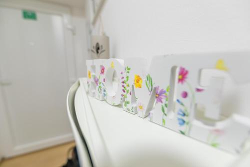 a white shelf with paper flowers on it at Apartman Lumi in Čakovec