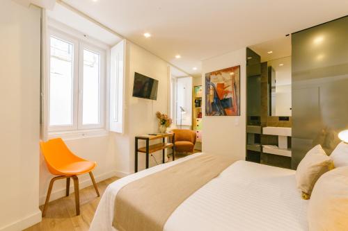 a bedroom with a bed and a window and a desk at Bairro Alto Music Guest House in Lisbon
