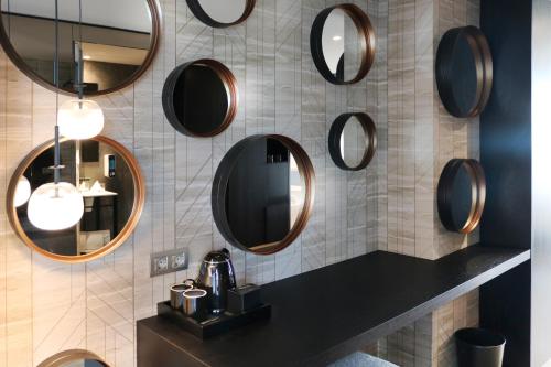 a bathroom with round mirrors on the wall at Hotel SB BCN Events 4* Sup in Castelldefels