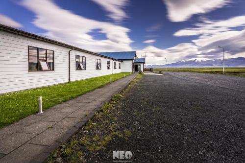 an empty road next to a white building at Hótel Fljótshlíd in Hlíðarendi