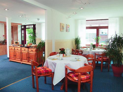 ein Esszimmer mit 2 Tischen und roten Stühlen in der Unterkunft City Apartment Hotel Hamburg in Hamburg