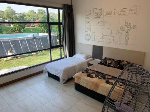 a bedroom with two beds and a large window at 2D Fantastic Villa Best HomeStay in Kampong Alor Gajah