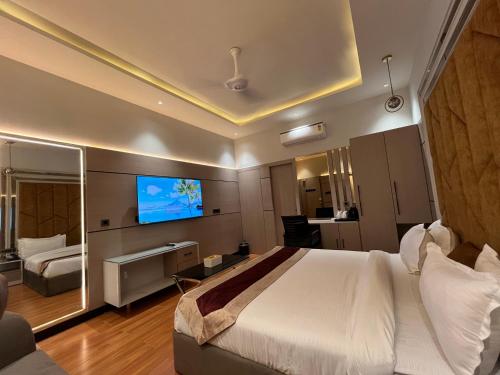 Habitación de hotel con cama grande y TV en Hotel The Seven Inn, en Gorakhpur