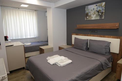 a bedroom with a bed with two towels on it at GÜNDOĞDU OTEL in Lapseki