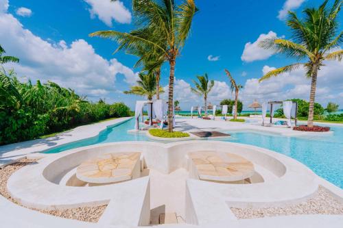 una piscina resort con 2 sillas y palmeras en Y Residential Luxury Villas en Dikoni