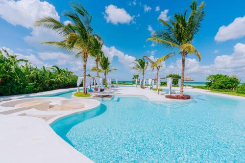 a pool at the resort with palm trees at Ycona Eco-Luxury Resort, Zanzibar in Dikoni