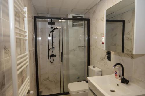 a bathroom with a shower and a toilet and a sink at GÜNDOĞDU OTEL in Lapseki