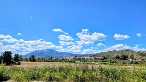 a field with mountains and a blue sky with clouds at Serendipity, La Caletta in La Caletta