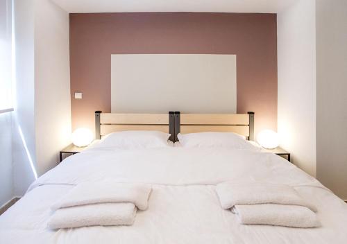 a bedroom with a white bed with towels on it at Snooze H in Athens