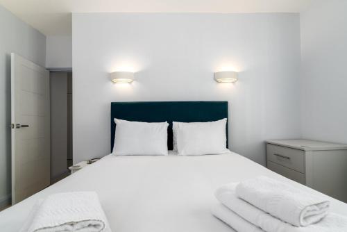 a bedroom with a white bed with towels on it at GuestReady - A British charm in South Bank in London