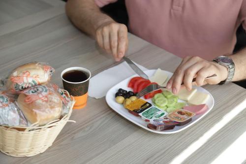 een persoon aan een tafel met een bord eten bij GÜNDOĞDU OTEL in Lapseki